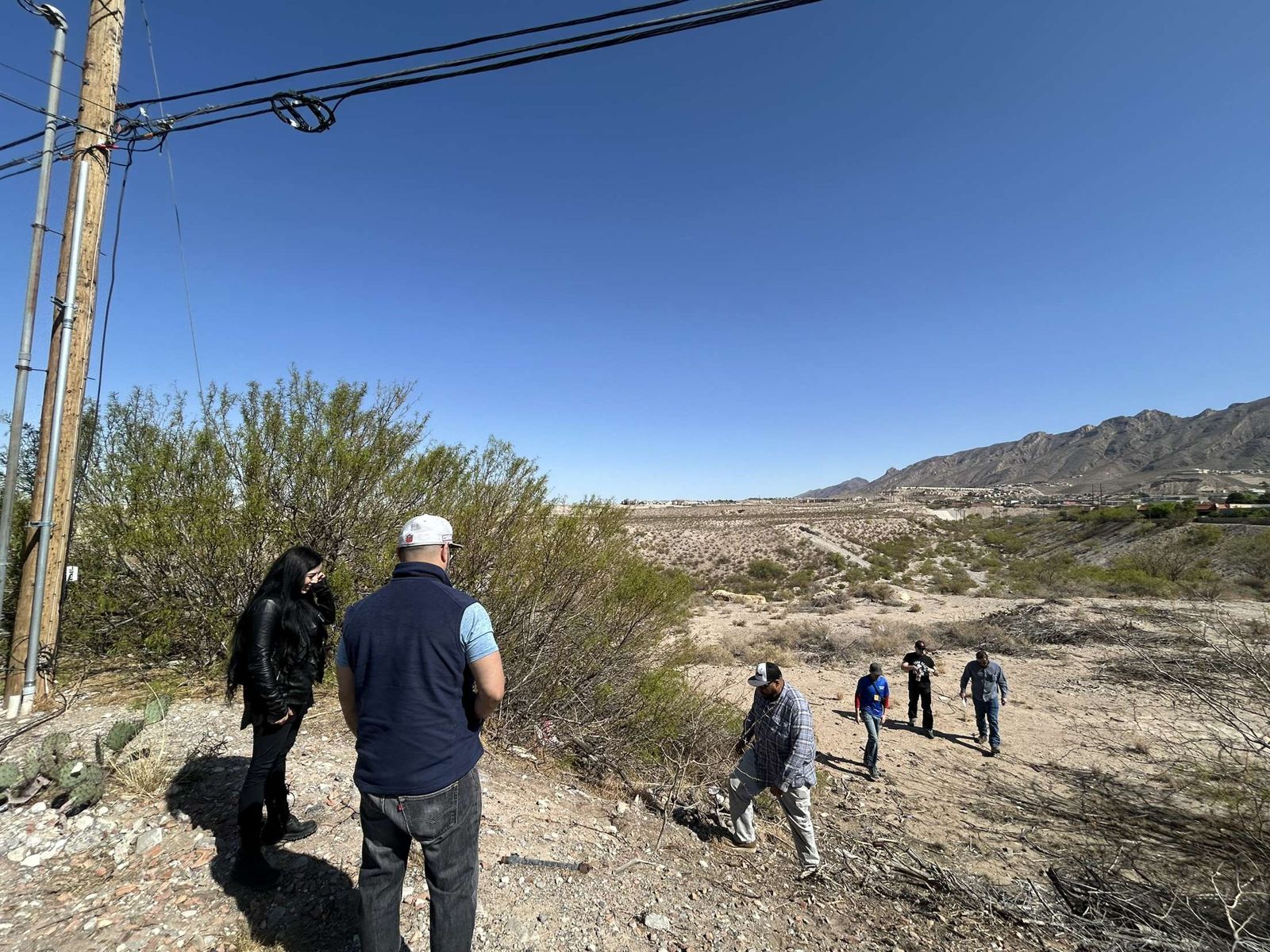 NMOI volunteers heading out on a desert outreach walk below the Franklin Mountains