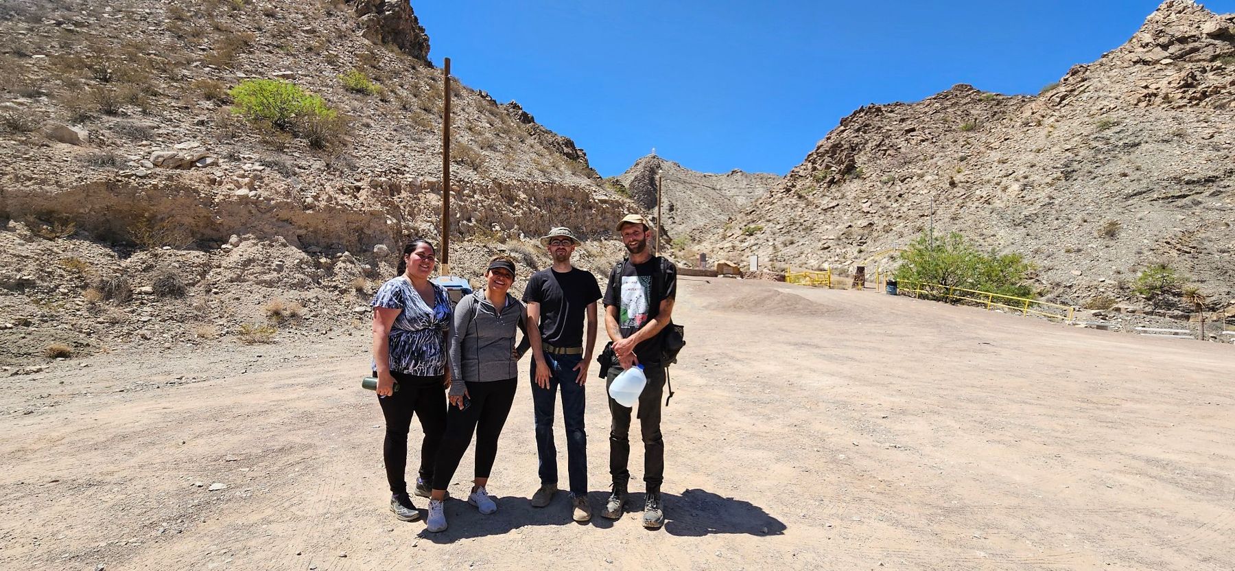 NMOI team members standing together on a desert trail